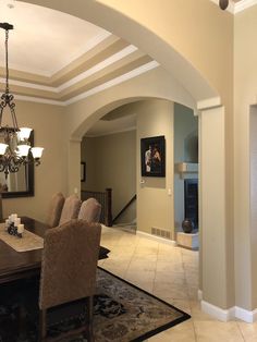 a formal dining room with chandelier, table and chairs in front of the fireplace