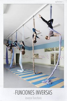 several people doing aerial acrobatic tricks in an empty room with blue and white walls