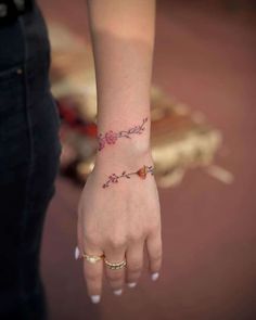 a woman's hand with a small tattoo on it