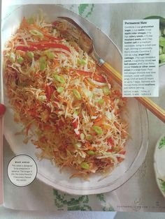 a plate with shredded carrots and other foods on it next to a bowl of vegetables