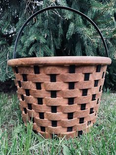 a basket sitting in the grass near some trees