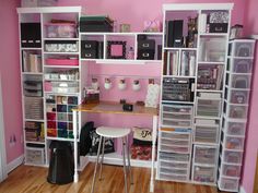 a room with pink walls and white shelves filled with crafting supplies on top of wooden floors