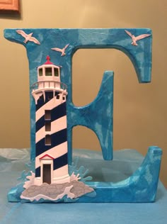 the letter f is made out of wood and has a lighthouse on it