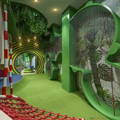 an indoor play area with climbing ropes and slides for children to slide down the hill