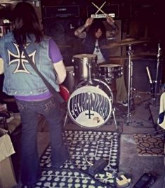 two people are playing drums in a room