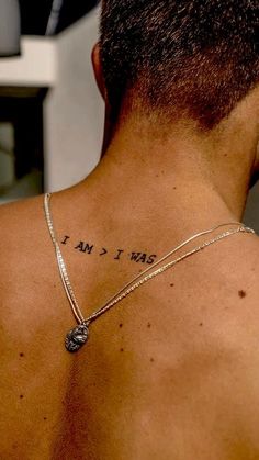 the back of a man's neck with words written on it and a coin