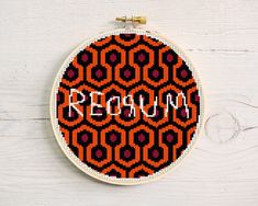 an orange and black pattern with the word reno written on it in white embroidery hoop