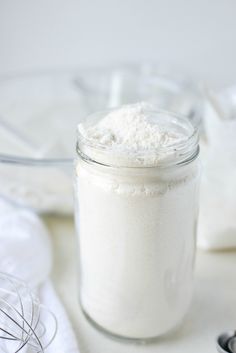 a glass jar filled with white powder on top of a table