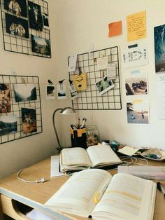 an open book sitting on top of a wooden desk next to a lamp and pictures