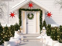 a white house decorated for christmas with presents and wreaths on the front door porch