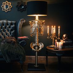 a living room with a skeleton lamp next to a chair and table filled with candles