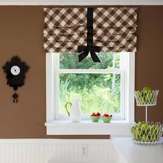 a kitchen with brown walls and checkered curtains, white counter tops, and an open window