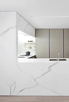 a kitchen with marble counter tops and white cabinets