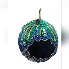 an ornament is decorated with green and blue sequins on white background