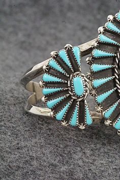 This turquoise and sterling silver bracelet was made by Zuni silversmith Carlos Tsipa. The inside of the cuff is signed C. Tspia.Size: 5 5/8" (will fit up to a 6 1/2" wrist)Gap: 7/8"Width: 2"Free shipping on all orders! We ship with USPS and always include tracking. All orders ship within a day of payment.Returns are accepted up to 30 days after you receive your order. Just send us a message. Our shop offers cash back or store credit. The item must be returned in new condition. Southwestern Sterling Silver Cuff Bracelet In Blue, Turquoise Sterling Silver Cuff Bracelet With Inlay, Sterling Silver Turquoise Cuff Bracelet With Inlay, Southwestern Blue Cuff Bracelet Stamped 925, Bear Carving, Pearl Chain, American Jewelry, Sterling Silver Bracelet, Native American Jewelry