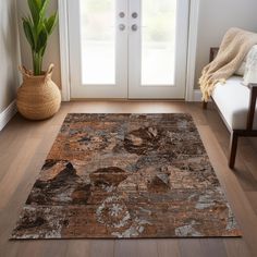 a living room with a large rug on the floor next to a chair and potted plant