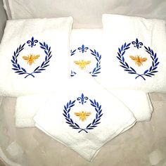 three white towels with blue and yellow designs on them sitting next to each other in a basket