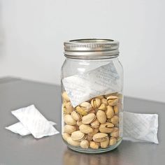 a jar filled with nuts sitting on top of a table next to a piece of paper