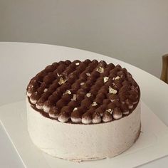 a white cake with chocolate frosting and nuts on top