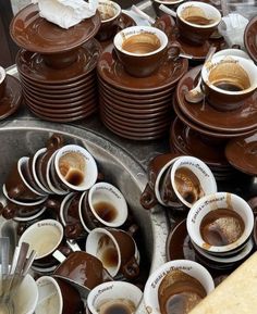 there are many cups and saucers that have been placed on the table for sale