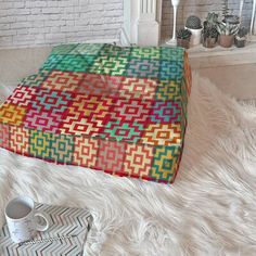 a multicolored square ottoman cover on a white furnishing