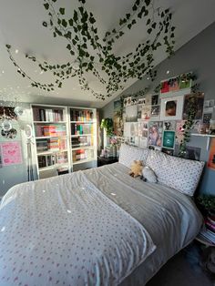 a bed room with a neatly made bed and lots of books on the shelves above it