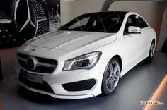 a white mercedes cla is on display in a showroom at an automobile dealership