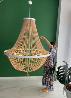 a woman standing in front of a chandelier that is hanging from the ceiling