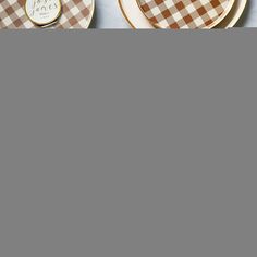 two plates with brown and white checkered designs on them, one has a gold disc