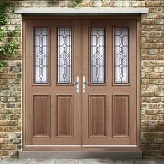 two double doors with stained glass in front of a brick wall and stone steps leading up to it