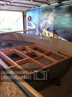 the inside of a boat being built in a building with wooden flooring and walls