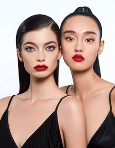 two women with red lipstick on their faces are posing for the camera and one is wearing a black dress