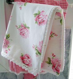 pink roses and white ruffles are hanging on the towel rack