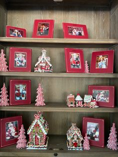 a shelf filled with christmas decorations and pictures on top of wooden shelves next to each other