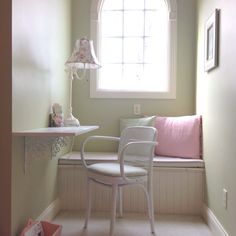 a white chair sitting next to a window with a lamp on it's side