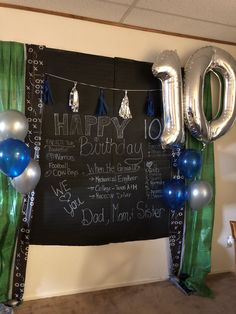 a chalkboard sign that says happy 10th birthday with balloons and streamers