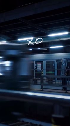 a train traveling past a station with the word xo on it