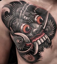 a man's chest with a tattoo design on it, and an image of a mask