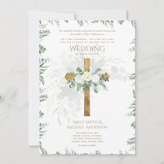 a wedding card with flowers and a cross on the front, in gold foil lettering