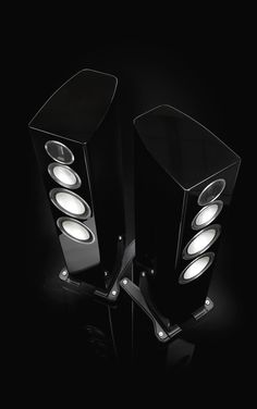 two black speakers with white lights on them