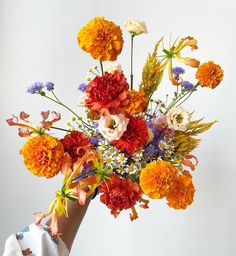 a person holding a bouquet of flowers in their hand