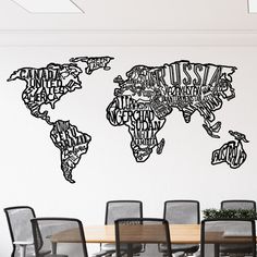 the world map is made up of words on a wall above a conference room table