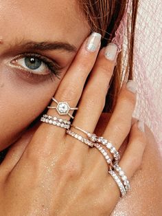 a woman with her hands on her face and two rings in front of her face