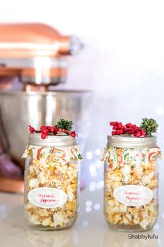 two jars filled with popcorn sitting on top of a counter