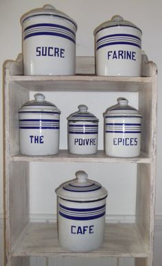 three shelves with blue and white dishes on top of each shelf in front of a wall