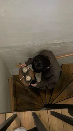 a man standing on top of a wooden stair case next to a cup and saucer