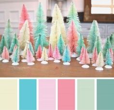 there are many different colored trees on the table in front of each other, including pink and blue