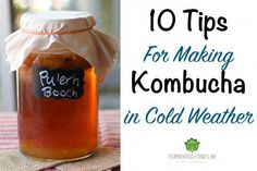 a glass jar filled with kombucha sitting on top of a table next to a