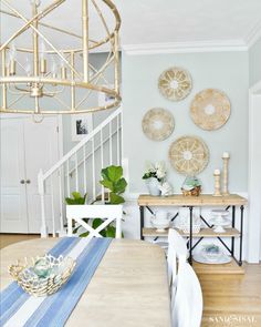 a dining room table with plates on the wall and a blue striped placemat in front of it