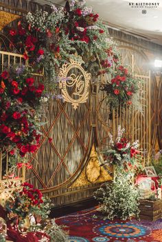 an elaborately decorated room with red flowers and greenery